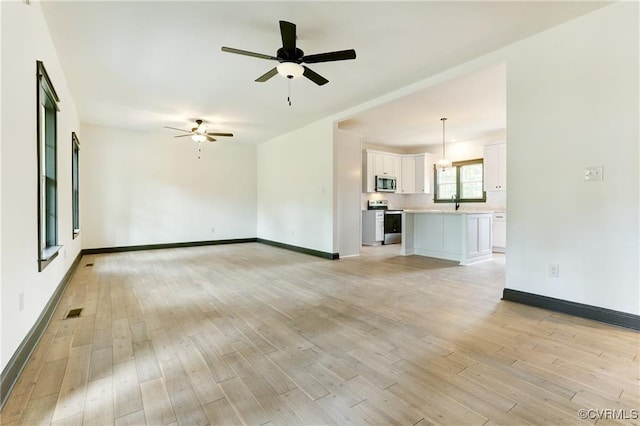 unfurnished living room with light hardwood / wood-style flooring and ceiling fan