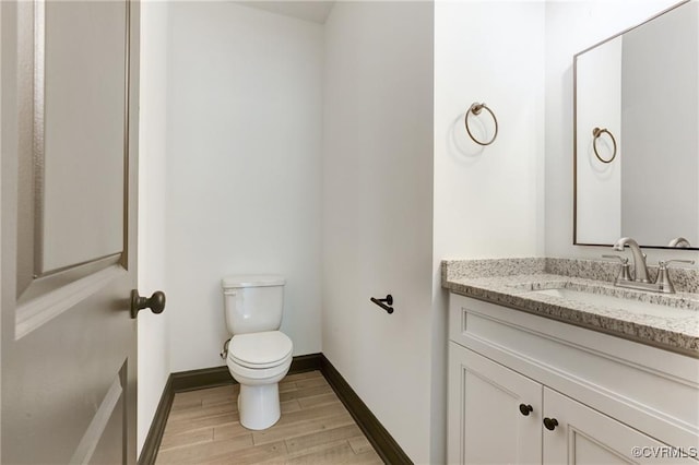 bathroom featuring hardwood / wood-style flooring, vanity, and toilet