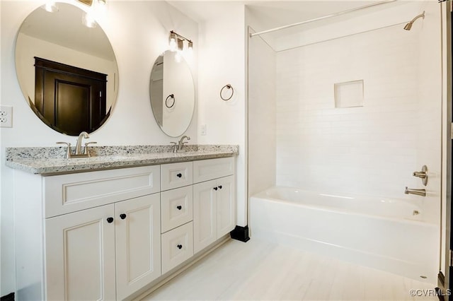 bathroom with tiled shower / bath and vanity