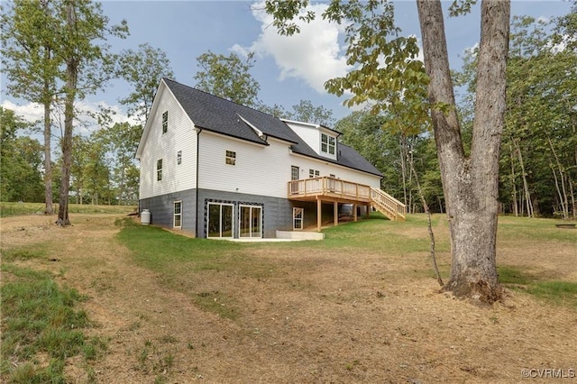 rear view of house featuring a wooden deck and a yard