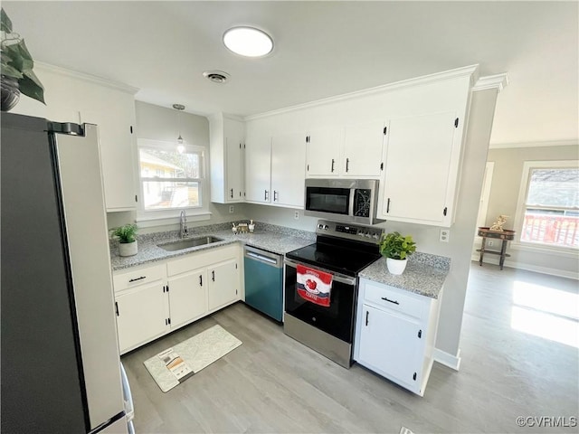 kitchen with crown molding, appliances with stainless steel finishes, sink, and white cabinets