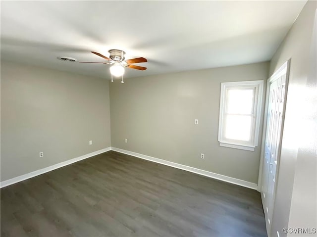 empty room with dark hardwood / wood-style floors and ceiling fan