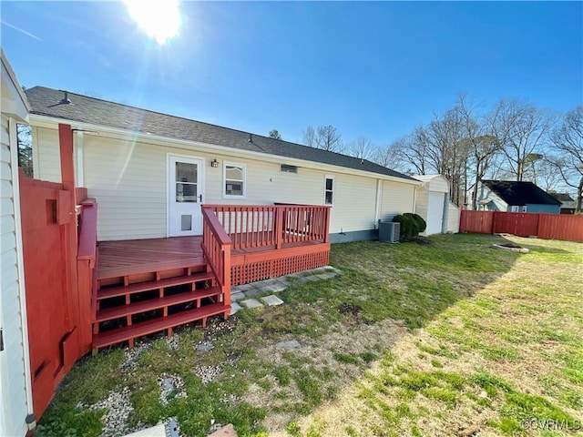 back of property with cooling unit, a deck, and a lawn