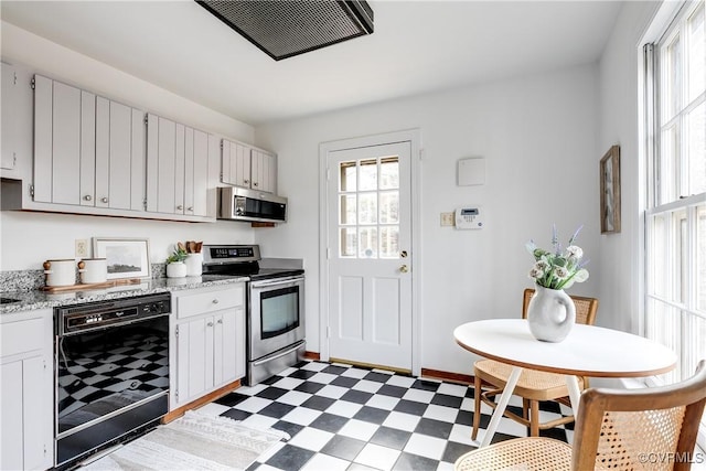 kitchen featuring stainless steel appliances, white cabinetry, and wine cooler