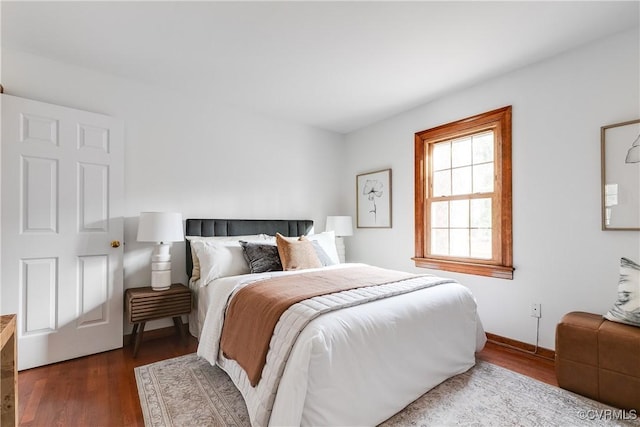 bedroom with dark hardwood / wood-style floors