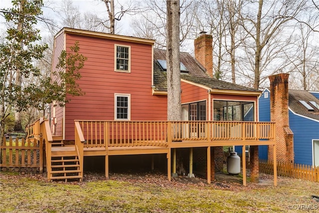 rear view of property with a deck and a sunroom