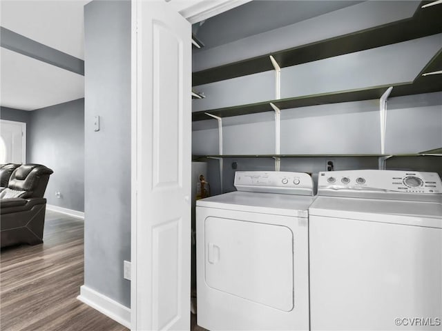 clothes washing area featuring wood-type flooring and washing machine and clothes dryer