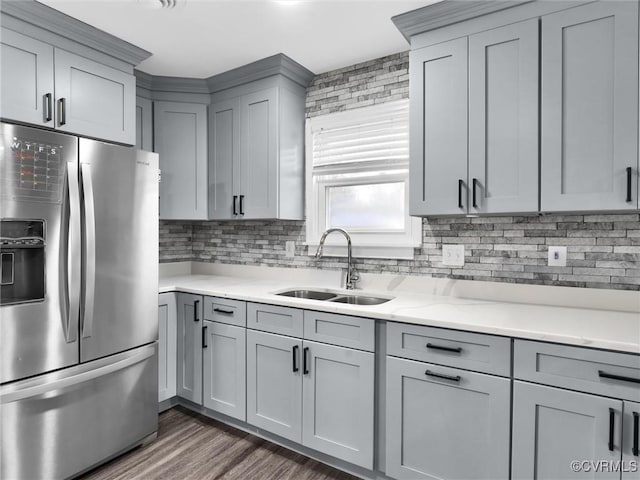 kitchen featuring sink, gray cabinets, dark wood-type flooring, stainless steel refrigerator with ice dispenser, and decorative backsplash