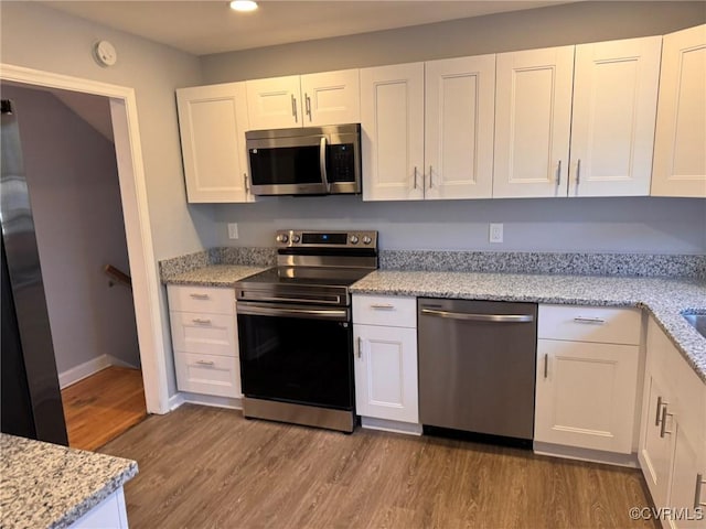 kitchen featuring white cabinetry, appliances with stainless steel finishes, and light stone counters