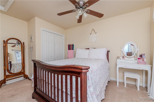 carpeted bedroom with ceiling fan and a closet