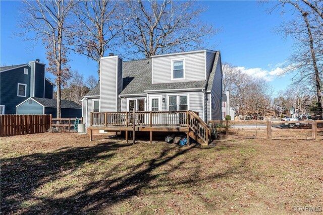 rear view of property with a deck and a lawn