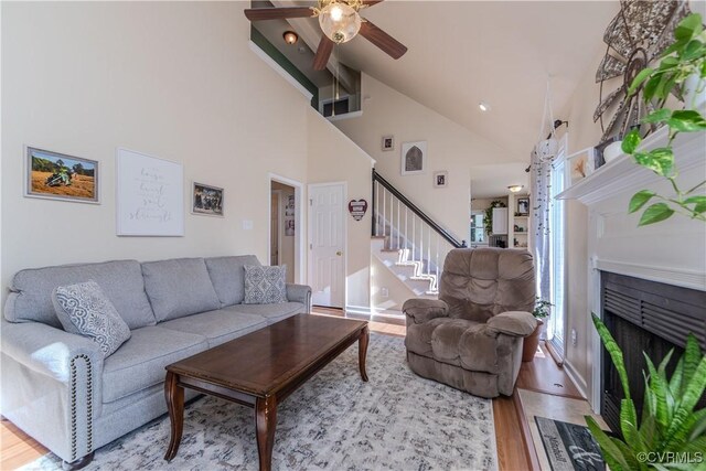 living room featuring hardwood / wood-style flooring, high vaulted ceiling, and ceiling fan