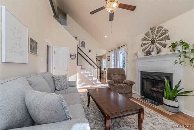 living room with ceiling fan, wood-type flooring, and high vaulted ceiling