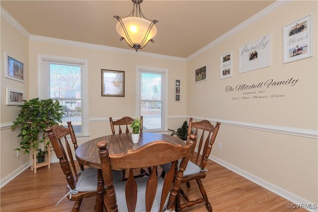 dining space featuring light hardwood / wood-style flooring, crown molding, and a wealth of natural light