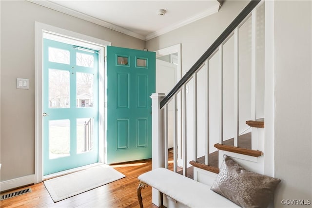 entryway featuring wood-type flooring and ornamental molding