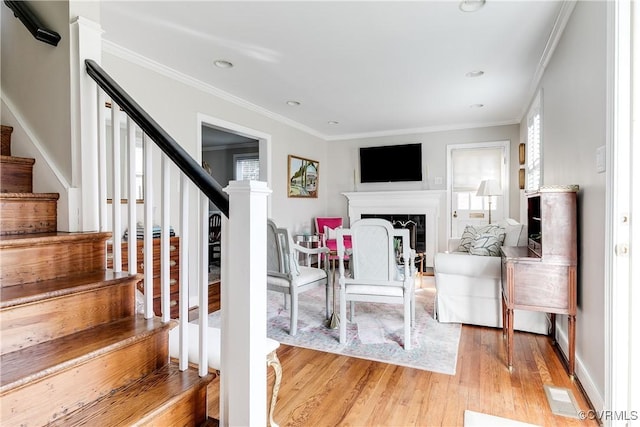 living room featuring ornamental molding and light hardwood / wood-style floors