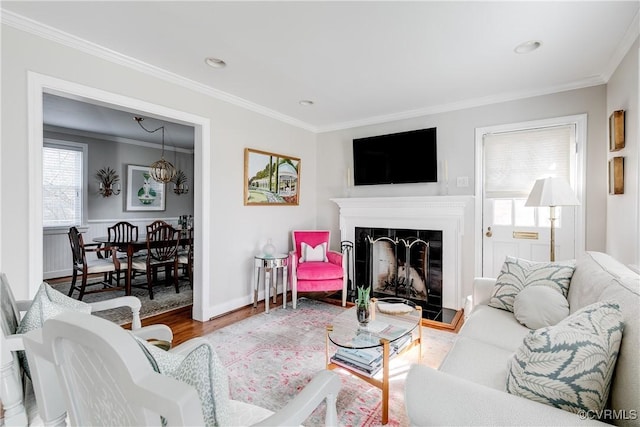 living room featuring hardwood / wood-style flooring, ornamental molding, and plenty of natural light