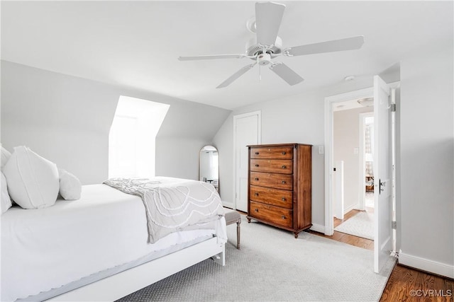 bedroom with lofted ceiling, hardwood / wood-style flooring, and ceiling fan