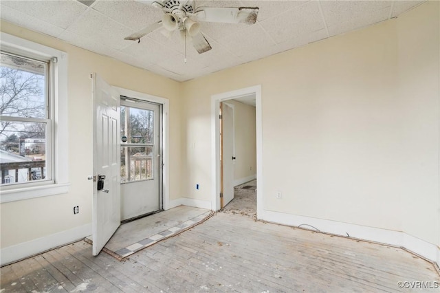 doorway featuring a healthy amount of sunlight, ceiling fan, and light hardwood / wood-style flooring