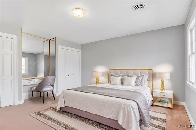 bedroom with a closet, carpet, visible vents, and baseboards