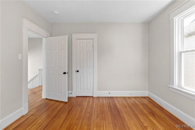 unfurnished bedroom featuring multiple windows and light wood-type flooring