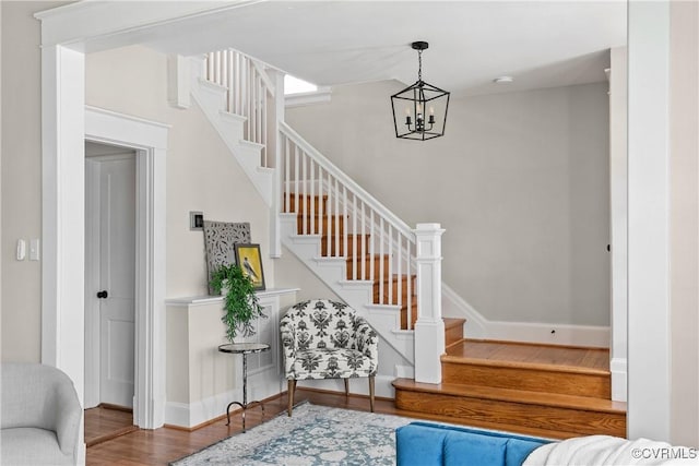 staircase featuring an inviting chandelier and hardwood / wood-style floors