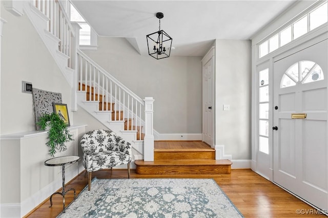 foyer entrance with an inviting chandelier and light hardwood / wood-style flooring