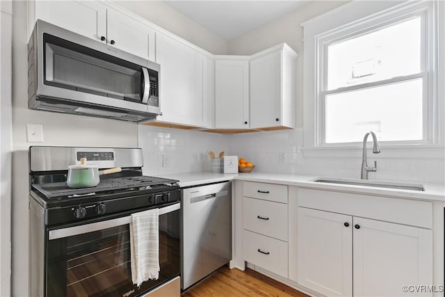 kitchen with sink, white cabinets, and appliances with stainless steel finishes