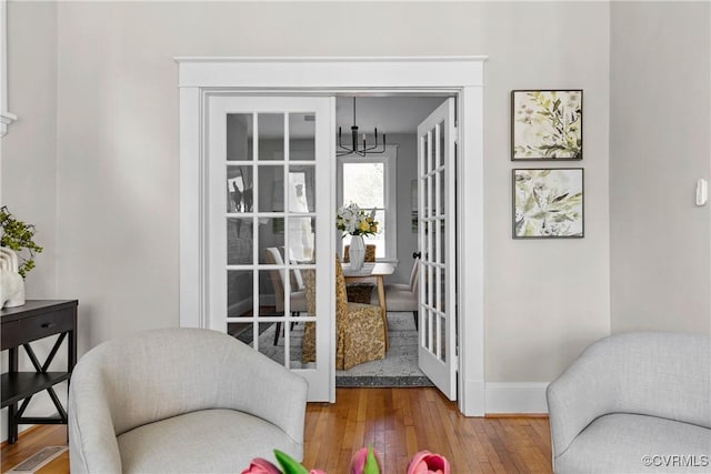 doorway to outside with hardwood / wood-style floors, a chandelier, and french doors