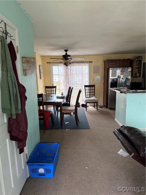 dining space featuring light carpet and ceiling fan