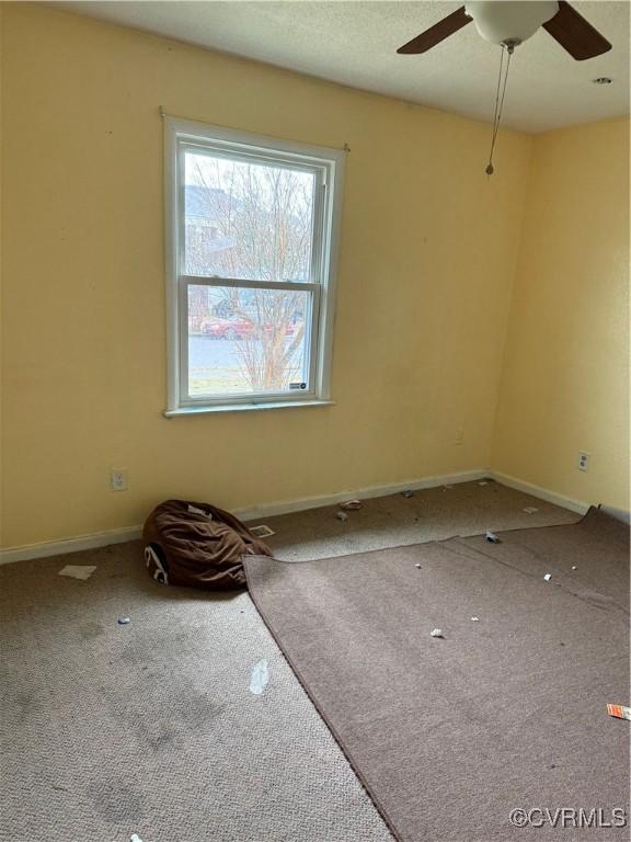 spare room featuring carpet and ceiling fan