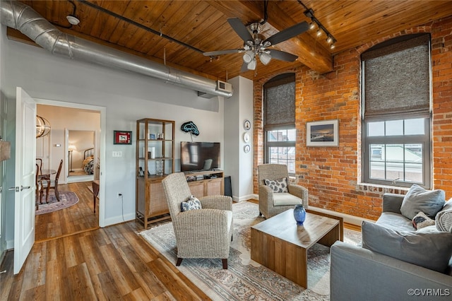 living room featuring a healthy amount of sunlight, brick wall, wood-type flooring, and wooden ceiling