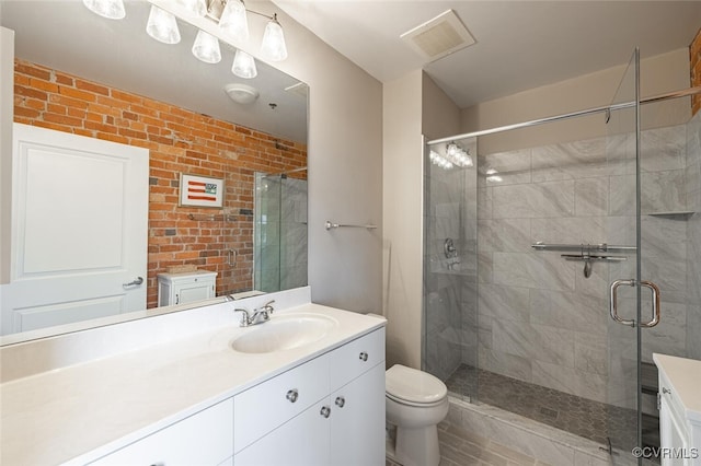 bathroom with vanity, toilet, and a shower with shower door