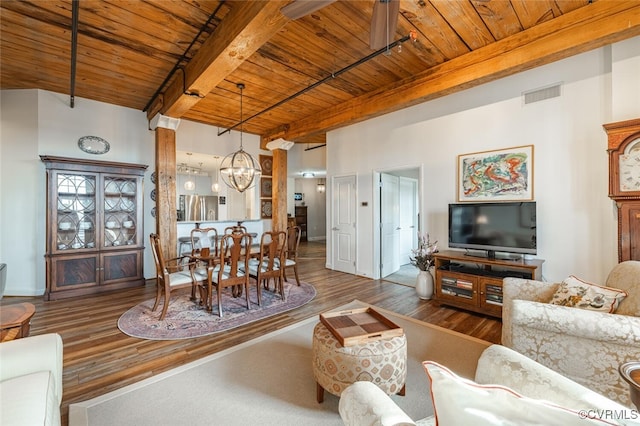 living room featuring an inviting chandelier, wood ceiling, wood-type flooring, and beamed ceiling