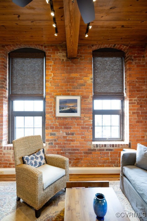 living room with wood ceiling, wood-type flooring, and brick wall