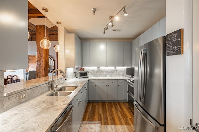 kitchen with sink, gray cabinetry, hanging light fixtures, stainless steel appliances, and kitchen peninsula