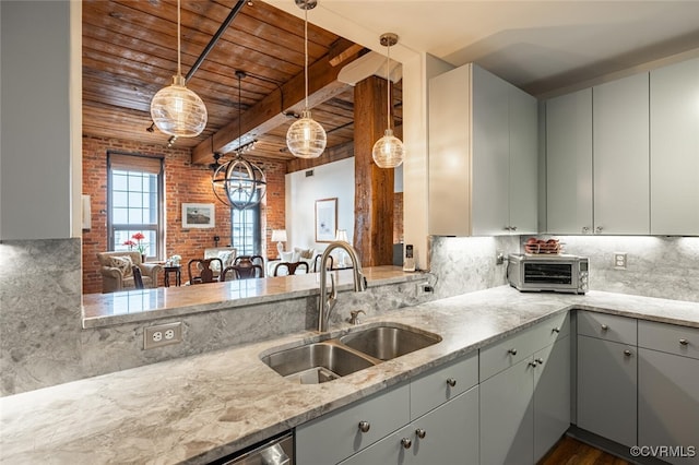 kitchen featuring brick wall, sink, light stone counters, and wood ceiling