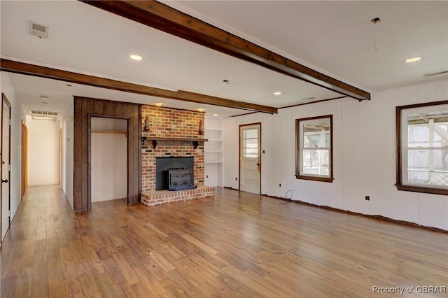 unfurnished living room with beamed ceiling and light hardwood / wood-style flooring