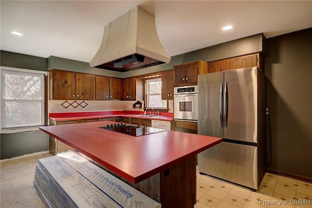 kitchen featuring premium range hood, appliances with stainless steel finishes, a center island, and sink