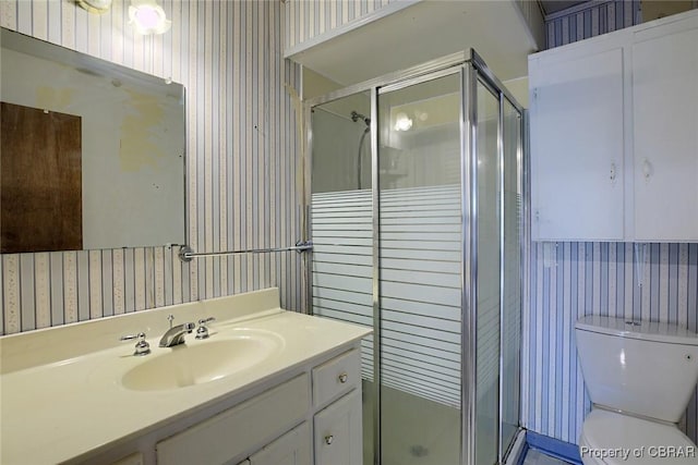 bathroom featuring vanity, an enclosed shower, and toilet