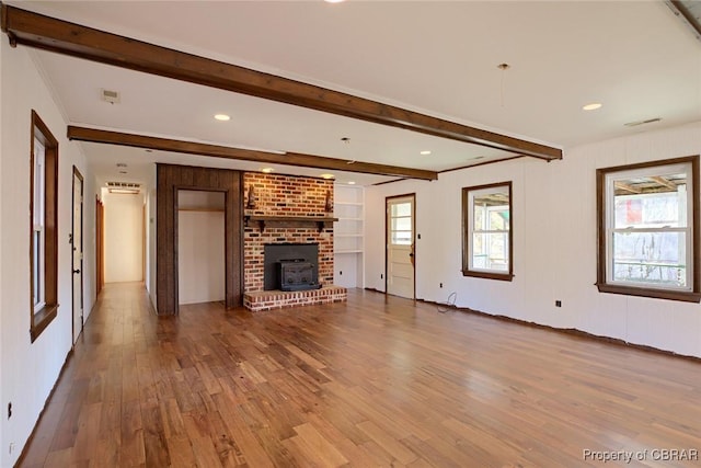 unfurnished living room with beam ceiling and wood-type flooring