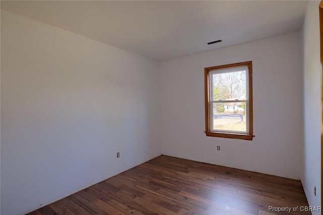 spare room featuring dark wood-type flooring