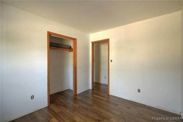 unfurnished bedroom featuring dark hardwood / wood-style flooring and a closet