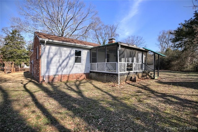 view of side of property with a lawn and a sunroom