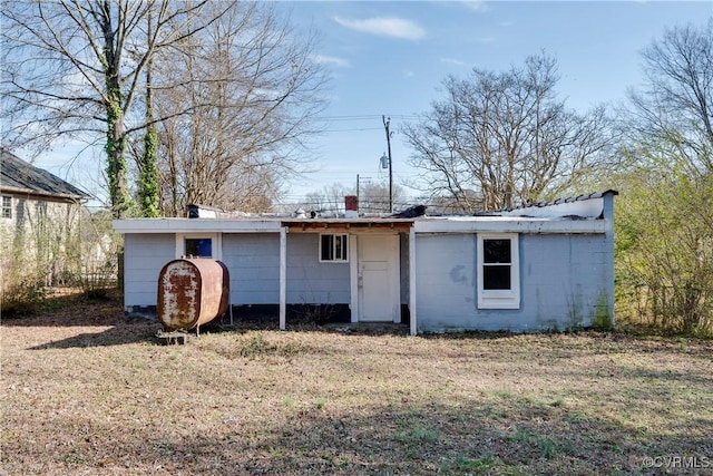 rear view of property featuring a yard