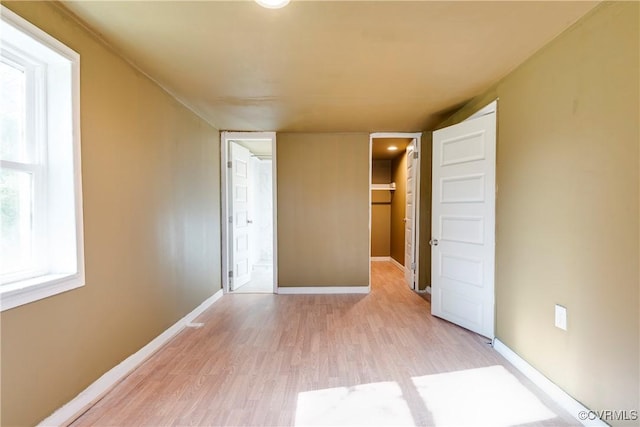 unfurnished bedroom with ensuite bath and light hardwood / wood-style floors