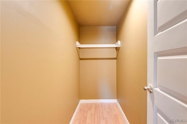 walk in closet with hardwood / wood-style flooring