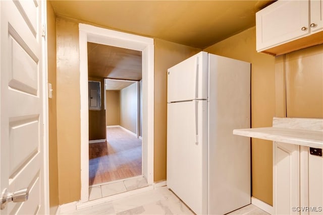 kitchen featuring white cabinetry and white fridge