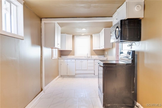 kitchen with white cabinetry, sink, and stainless steel electric range oven