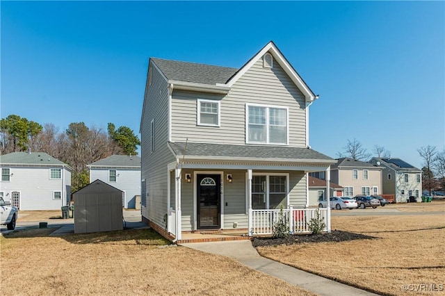 view of property featuring a storage shed, a front lawn, and a porch